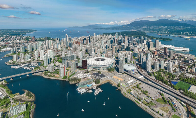 Aerial view of downtown Vancouver with False Creek and the North Shore Mountains in the distance